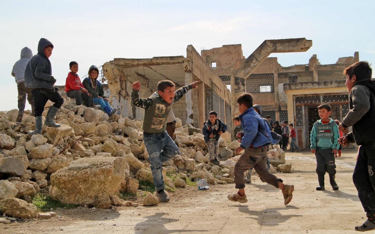 Syrian children play in a bombed schoolyard - AFP