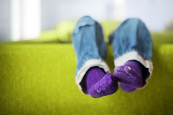 feet hanging over sofa.