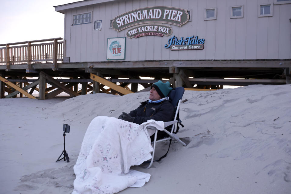 Peter Flynn of Myrtle Beach sits on the beach near the Springmaid Pier, Saturday, Feb. 4, 2023, in Myrtle Beach, S.C. He witnessed the Chinese balloon getting shot down in this area earlier in the day. (AP Photo/Chris Seward)