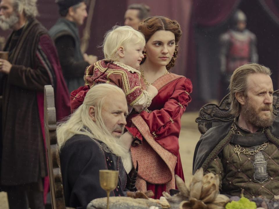 Viserys Aegon Alicent and Otto all sitting down at a table of food.