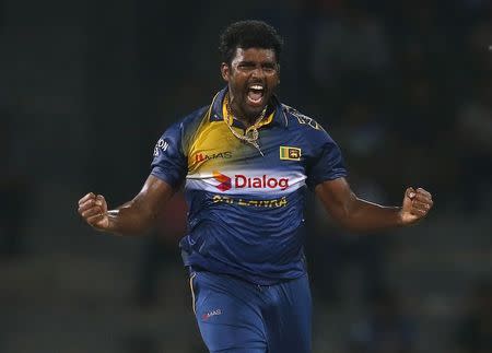 Sri Lanka's Thisara Perera (L) celebrates after taking the wicket of England's Joe Root (not pictured) during their first ODI (One Day International) cricket match in Colombo November 26,2014. REUTERS/Dinuka Liyanawatte