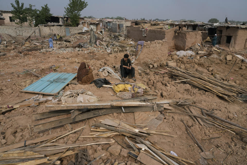 An Afghan family rests over the rubble as others retrieve useful stuff from their damage mud homes demolished by authorities during a crackdown against an illegal settlement and immigrants, on the outskirts of Islamabad, Pakistan, Wednesday, Nov. 1, 2023. (AP Photo/Anjum Naveed)