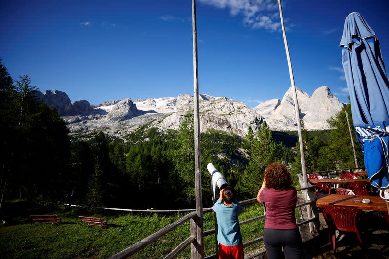 Un grupo de personas observa el lugar donde se ha producido un derrumbe mortal de partes de un glaciar de montaña en los Alpes italianos en medio de temperaturas récord, en la cresta de Marmolada, Italia