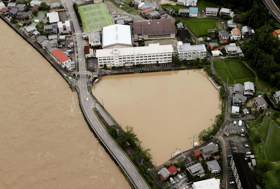 A schoolyard of a junior high school is seen flooded following heavy rains in Gero, Gifu prefecture, southern Japan Wednesday, July 8, 2020. Floodwaters flowed down streets in southern Japanese towns hit by heavy rains. (Kyodo News via AP)