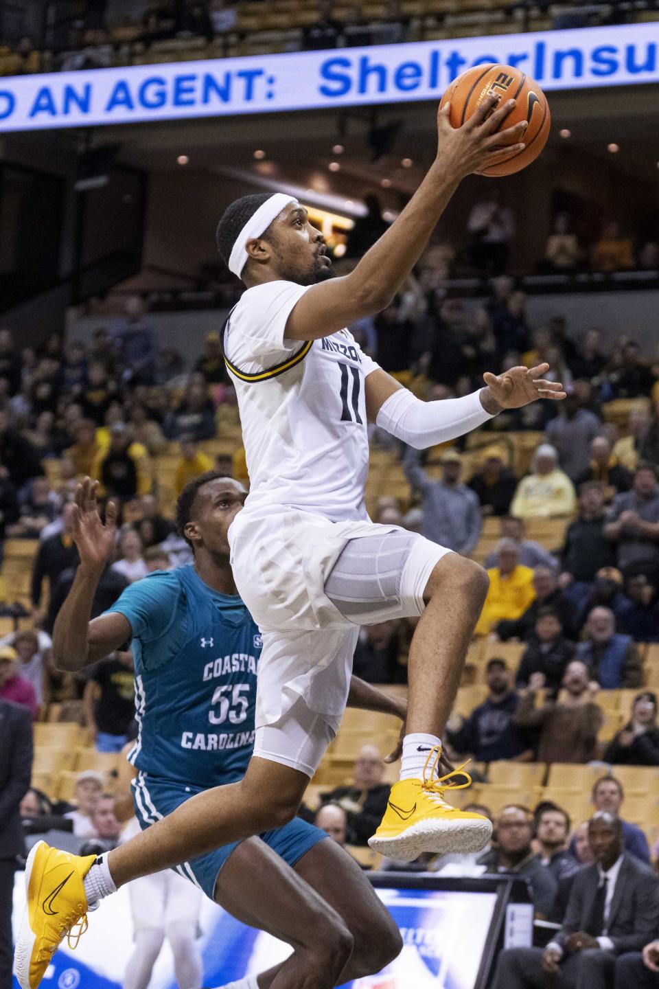 Missouri's Isiaih Mosley, right, shoots past Coastal Carolina's Jimmy Nichols, left, during the second half of an NCAA college basketball game Wednesday, Nov. 23, 2022, in Columbia, Mo. Missouri won 89-51.(AP Photo/L.G. Patterson)