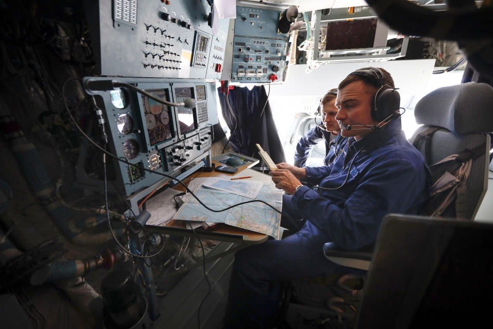 Russian military cargo plane Il-76 crew members work during a flight to the Alexandra Land island of the Franz Josef Land archipelago, Russia, Monday, May 17, 2021. Once a desolate home mostly to polar bears, Russia's northernmost military outpost is bristling with missiles and radar and its extended runway can handle all types of aircraft, including nuclear-capable strategic bombers, projecting Moscow's power and influence across the Arctic amid intensifying international competition for the region's vast resources. (AP Photo/Alexander Zemlianichenko)