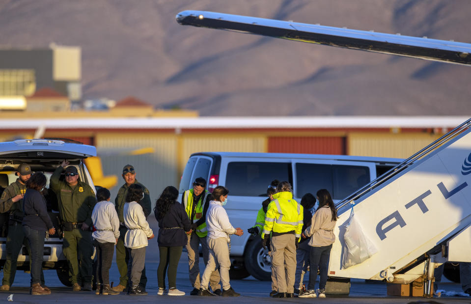 Shackled migrants board a U.S. Immigration and Customs Enforcement repatriation flight to Guatemala in El Paso, Texas, Wednesday, May 10, 2023. The U.S. on May 11 will begin denying asylum to migrants who show up at the U.S.-Mexico border without first applying online or seeking protection in a country they passed through, according to a new rule released May 10. (AP Photo/Andres Leighton)