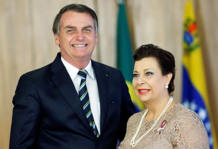 Brazil's President Jair Bolsonaro stands with Venezuela's ambassador to Brazil Maria Teresa Belandria during the credentials presentation ceremony of several new diplomats, in Brasilia