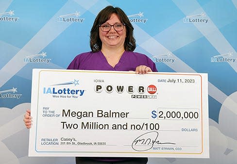 Megan Balmer of Tama County accepts her $2 million lottery prize at the Iowa Lottery headquarters in Clive on July 11.