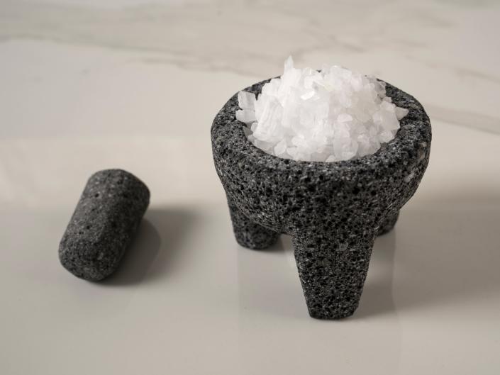 Gray bowl of salt on white countertop