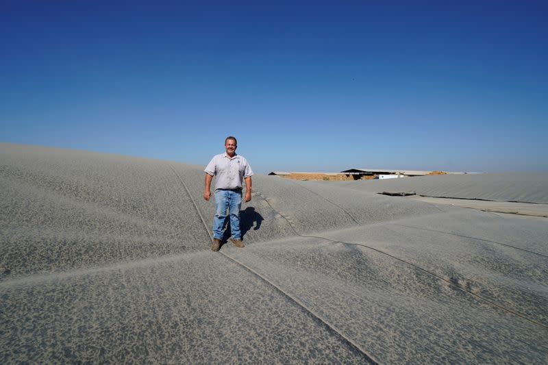 FILE PHOTO: Dairy farmer Joey Airoso stands on top of a methane collecting dome that covers one of his farm's waste collecting ponds in Pixley, California