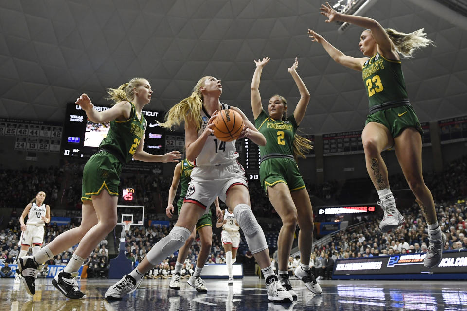 UConn's Dorka Juhasz (14) looks to shoot against Vermont's Anna Olson (24), Vermont's Aryana Dizon (2) and Vermont's Emma Utterback (23) in the first half of a first-round college basketball game in the NCAA Tournament, Saturday, March 18, 2023, in Storrs, Conn. (AP Photo/Jessica Hill)