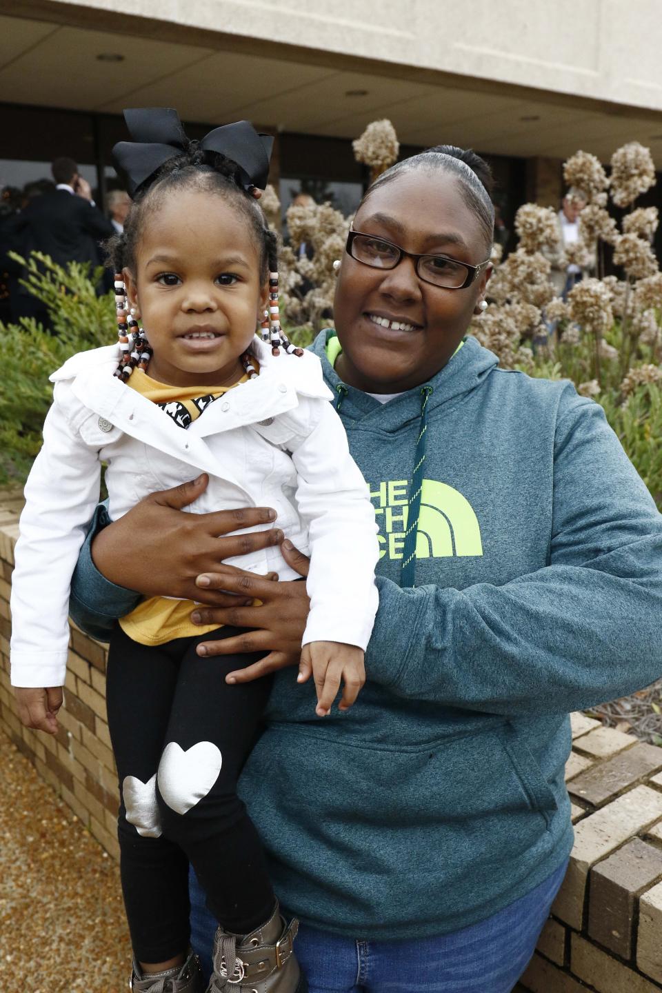 Crystal Ghoston, right, and her daughter Ariel Blackmon, 2, are all smiles Monday, Dec. 16, 2019 after a Mississippi circuit judge ordered bail for Curtis Flowers, Ghoston's father, whose murder conviction was overturned by the U.S. Supreme Court for racial bias . Flowers was granted bond Monday and will be free for the first time in 22 years, following a hearing in Winona, Miss. (AP Photo/Rogelio V. Solis)