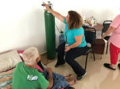 Dr. Lourdes Marrero shows a patient how to use an oxygen tank if the generator fails at a public shelter in Orocovis, Puerto Rico on October 3, 2017. REUTERS/Robin Respaut