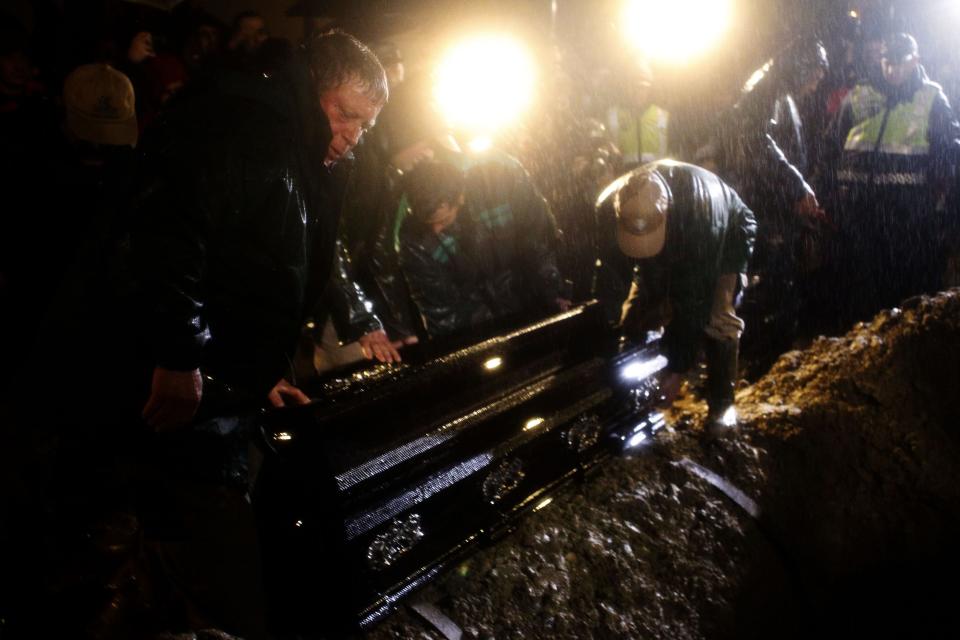 The coffin of Portuguese soccer great Eusebio is lowered into the ground at Lumiar cemetery in Lisbon