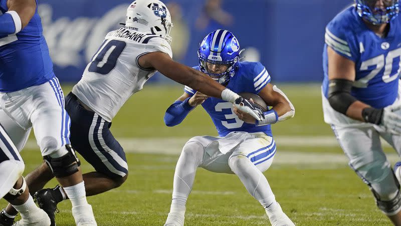 BYU quarterback Jaren Hallis sacked by Utah State linebacker AJ Vongphachanh during game Thursday, Sept. 29, 2022, in Provo, Utah. The former USU standout will be wearing royal blue this fall for the Cougars.