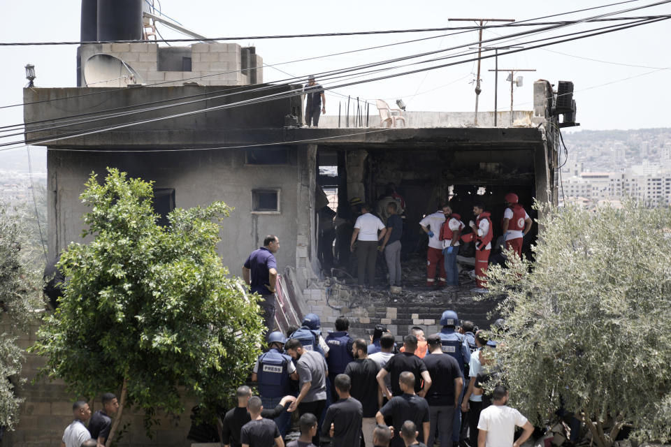 Palestinian first responders work in the rubble of a home destroyed in an Israeli military operation in the West Bank city of Jenin, Friday, July 5, 2024. The Israeli military said Friday it was conducting counterterrorism activity that included an airstrike in the area of the West Bank city of Jenin. Palestinian authorities said five people were killed. (AP Photo/Majdi Mohammed)