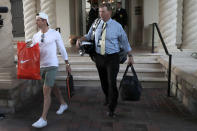 Rory McIlroy, left, leaves the clubhouse after the PGA tour canceled the rest of The Players Championship golf tournament as a result of the coronavirus pandemic, Friday, March 13, 2020, in Ponte Vedra Beach, Fla. The PGA Tour first said there would be no fans. Now there will be no players. In a late Thursday night decision, the PGA Tour canceled the rest of The Players Championship and said it would not play the next three weeks. (AP Photo/Lynne Sladky)