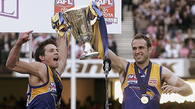 Cousins and Judd holding the AFL premiership trophy aloft. Pic: Getty