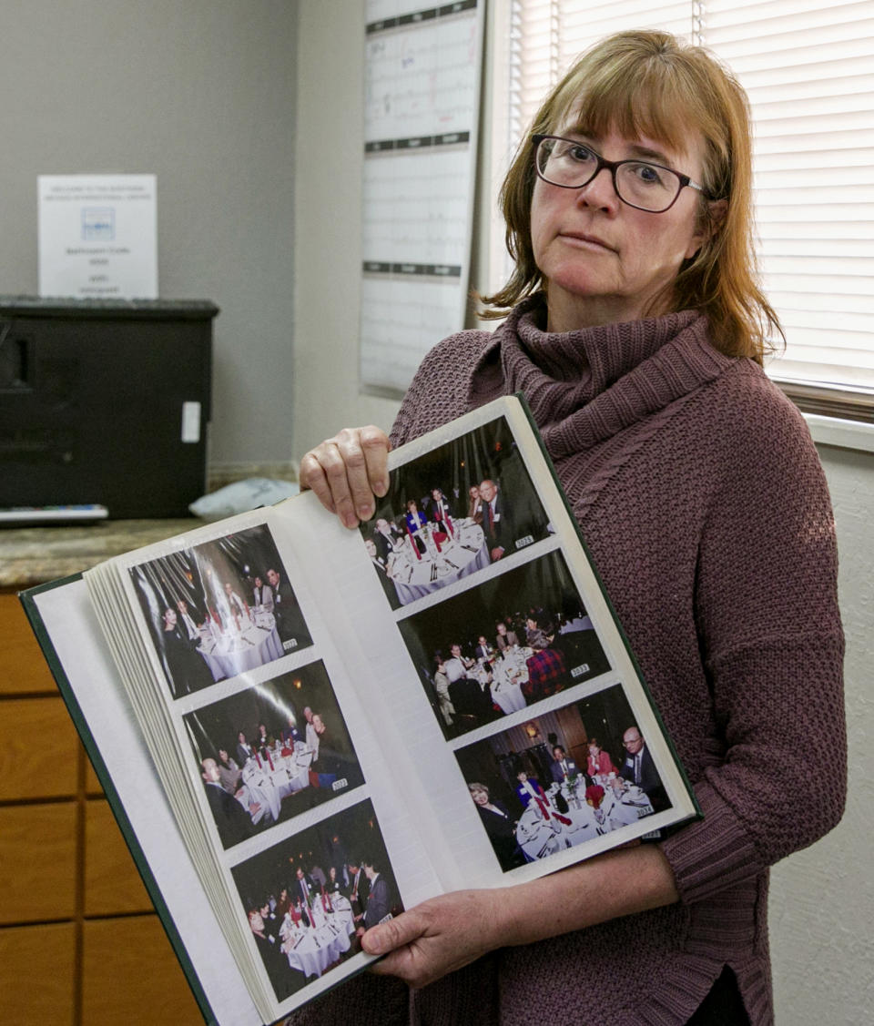 In this Monday, Feb. 11, 2019 photo, Carina Black poses in her office in Reno, Nev., holding a photo album containing dozens of photos of a dinner she attended where Nobel Peace Prize winner and former Costa Rican President Oscar Arias spoke on April 6, 1998. Black, the longtime director of the international center at the University of Nevada in Reno, is the latest woman to accuse Arias of sexual misconduct. (AP Photo/Tom R. Smedes)