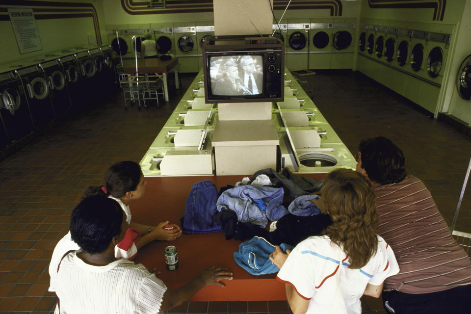 Patrons at a laundromat watch the televised broadcast of Lt. Col. Oliver L. North's testimony before the joint Congressional hearing into Iran-Contra affair on July 1, 1987. (Steve Liss / Getty Images file)