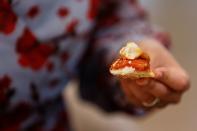 The representative director of Japan Association for Cellular Agriculture holds up a morsel of a dish containing 3D-printed cultivated grouper fish during a tasting at the offices of Steakholder Foods in Rehovot