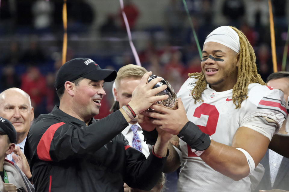 FILE - In this Dec. 8, 2019, file photo, Ohio State coach Ryan Day, left, and defensive end Chase Young (2) hold the trophy following the team's Big Ten championship NCAA college football game against Wisconsin, in Indianapolis. Ryan Day was named the Big Ten Coach of the Year and Chase Young was selected to The Associated Press All-Big Ten Conference football team, Wednesday, Dec. 11, 2019. (AP Photo/AJ Mast, File)