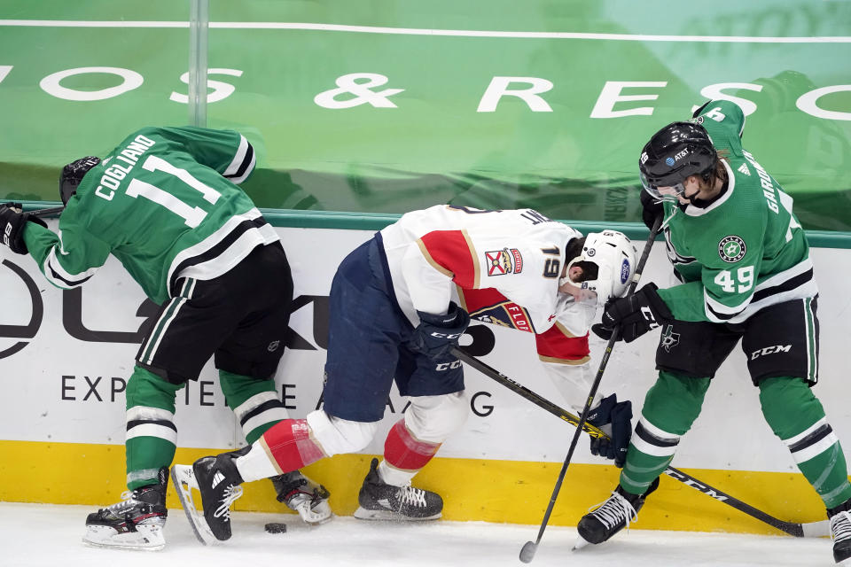 Dallas Stars center Andrew Cogliano (11) and center Rhett Gardner (49) work to control the puck in front of Florida Panthers left wing Mason Marchment (19) in the second period of an NHL hockey game in Dallas, Saturday, April 10, 2021. (AP Photo/Tony Gutierrez)
