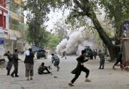 People run for cover after an explosion in Jalalabad April 18, 2015. A suicide bomb blast in Afghanistan's eastern city of Jalalabad killed 33 people and injured more than 100 outside a bank where government workers collect salaries, the city's police chief said on Saturday. (REUTERS/Parwiz)