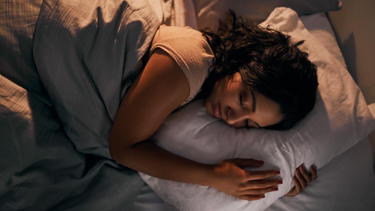 High angle shot of a beautiful young woman sleeping in her bed at home during the night.