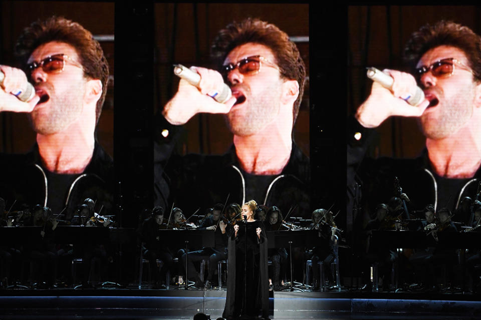 An image of the late George Michael is projected on a video screen while recording artist Adele