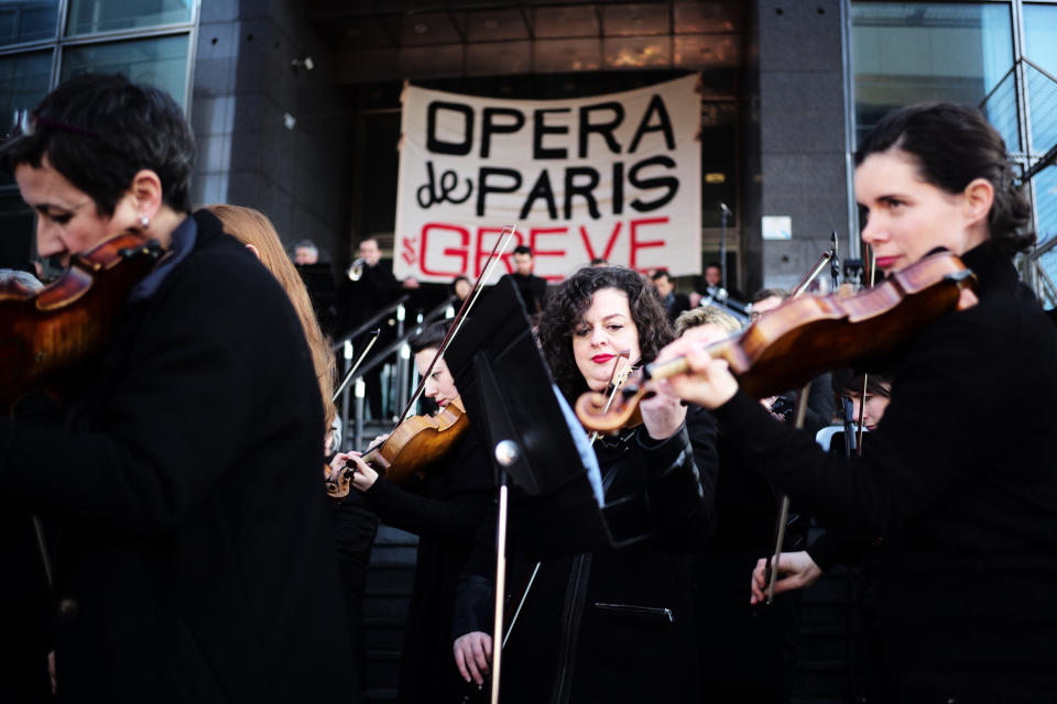 Striking musicians of the Paris Opera house perform outside the Bastille Opera house Tuesday, Dec. 31, 2019 in Paris. Banner reads : Paris Opera on strike. (AP Photo/Kamil Zihnioglu)