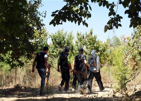 Free Syrian Army fighters carry their weapons as they move towards their positions in the eastern al-Ghouta, near Damascus September 8, 2013. REUTERS/Msallam Abd Albaset