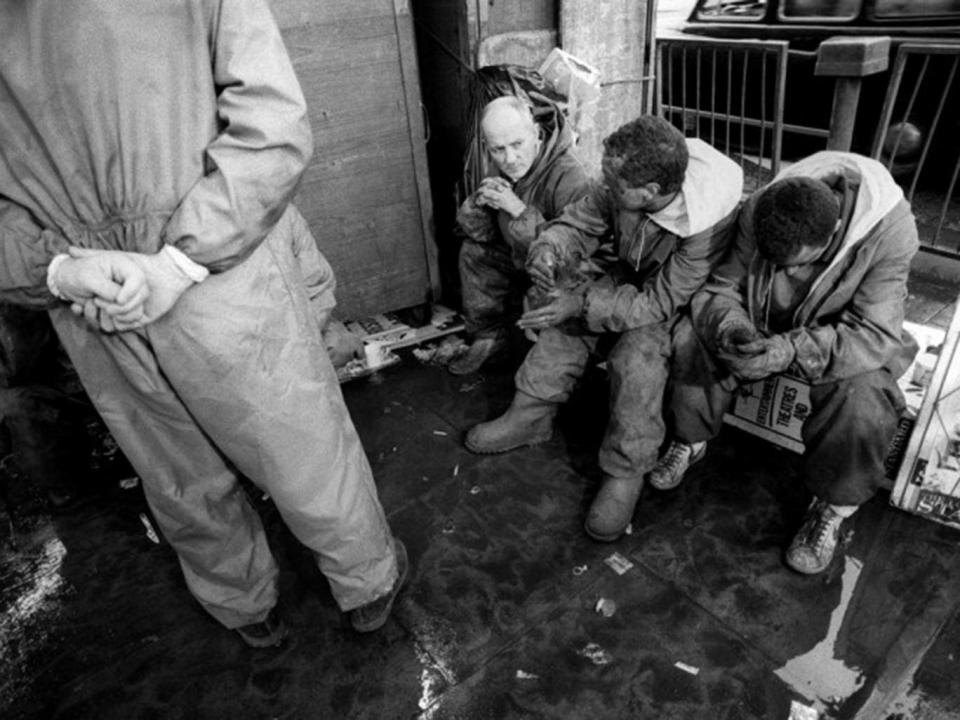 Devastated workers rest outside the station during the King’s Cross Tube fire disaster (Independent)