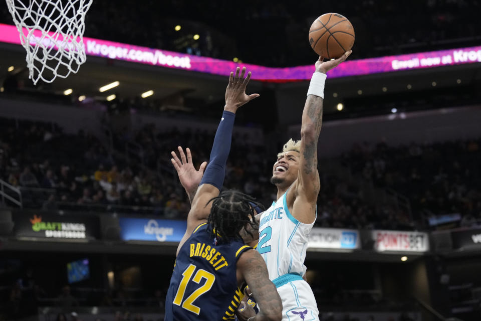 Charlotte Hornets guard Kelly Oubre Jr., right, shoots over Indiana Pacers forward Oshae Brissett during the first half of an NBA basketball game in Indianapolis, Wednesday, Jan. 26, 2022. (AP Photo/AJ Mast)