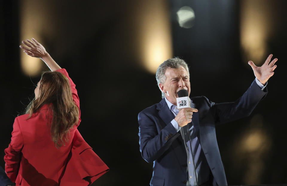 Argentine President Mauricio Macri, who is running for reelection with the "Juntos Por el Cambio" party, speaks to supporters as his wife Juliana Awada waves during his campaign rally in Cordoba, Argentina, Thursday, Oct. 24, 2019. Argentina will hold its presidential election on Oct. 27. (AP Photo/Nicolas Aguilera)