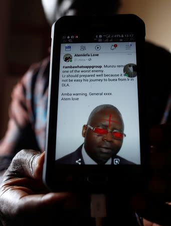 Simon Munzu, a former UN official, who is campaigning for peace in the Anglophone regions of Cameroon, shows a threat message posted against him on social media by separatists during an interview with Reuters in Yaounde, Cameroon October 3, 2018. Picture taken October 3, 2018. REUTERS/Zohra Bensemra