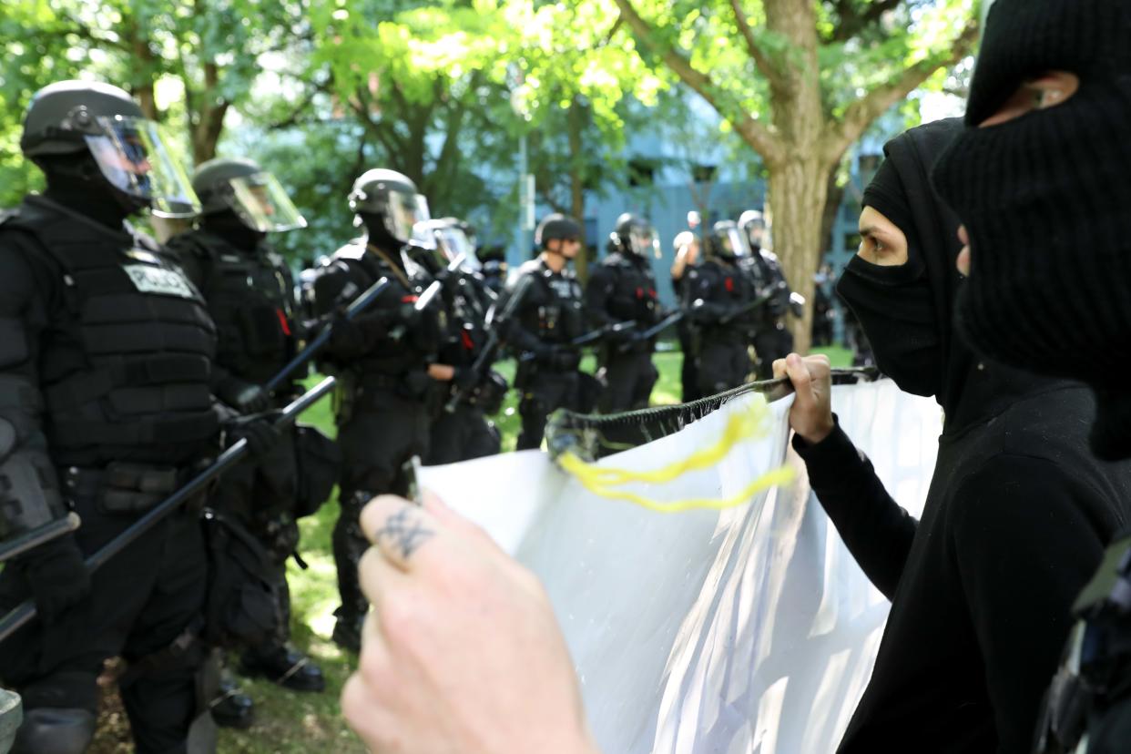 Black-clad protesters in Portland, Oregon, faced off against officers who kept them separated from pro-Trump demonstrators. (Photo: John Rudoff for HuffPost)
