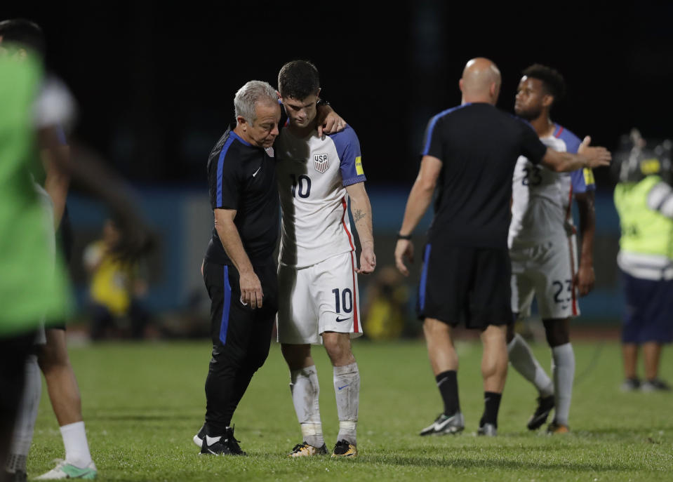 United States’ Christian Pulisic (C) is comforted after losing 2-1 against Trinidad and Tobago. (AP)