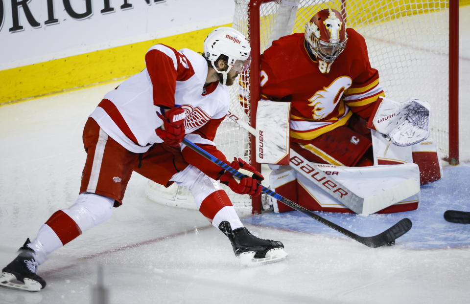 Detroit Red Wings forward Michael Rasmussen, left, tries to score against Calgary Flames goalie Dan Vladar during second-period NHL hockey game action in Calgary, Alberta, Thursday, Feb. 16, 2023. (Jeff McIntosh/The Canadian Press via AP)