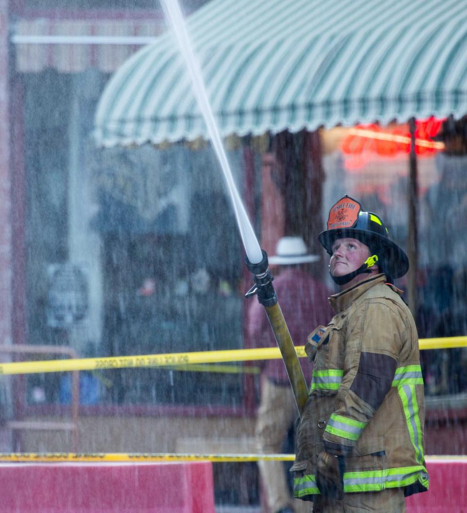 Firefighters hose down a building on Main St. in Bisbee, AZ on Feb. 15, 2024.
