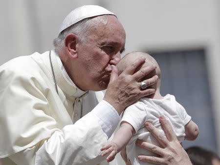 Pope Francis kisses a baby as he leaves at the end of his Wednesday general audience in Saint Peter's square at the Vatican June 17, 2015. REUTERS/Max Rossi -