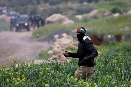 A Palestinian demonstrator runs during clashes with Israeli troops at a protest marking the Land Day, in al-Mughayer village in the Israeli-occupied West Bank March 29, 2019. REUTERS/Mohamad Torokman