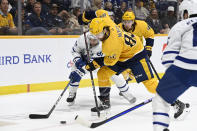 Toronto Maple Leafs center John Tavares, left, and Nashville Predators center Tommy Novak vie for the puck during the first period of an NHL hockey game, Sunday, March 26, 2023, in Nashville, Tenn. (AP Photo/Mark Zaleski)