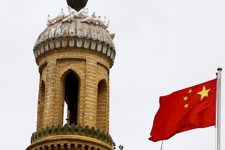 FILE PHOTO: A Chinese national flag flutters near a minaret of the ancient Id Kah Mosque in the Old City in Kashgar in Xinjiang Uighur Autonomous Region, China September 6, 2018. REUTERS/Thomas Peter/File Photo