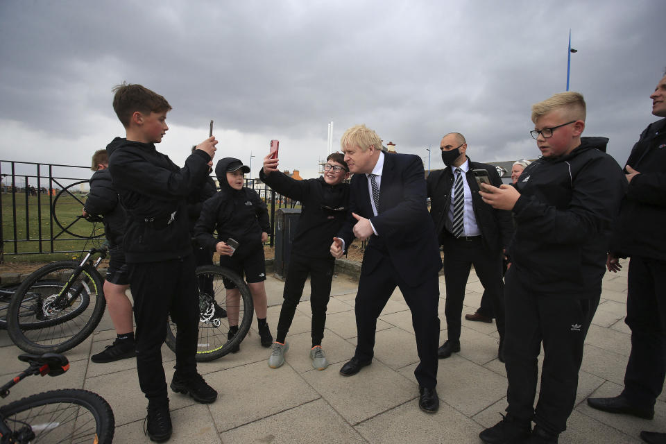 Britain's Boris Johnson, centre right, poses for a 'selfie', as he meets members of the public while campaigning on behalf of Conservative Party candidate Jill Mortimer, in Hartlepool, England, Monday, May 3, 2021, ahead of the 2021 Hartlepool by-election to be held on May 6. (Lindsey Parnaby/PA via AP)