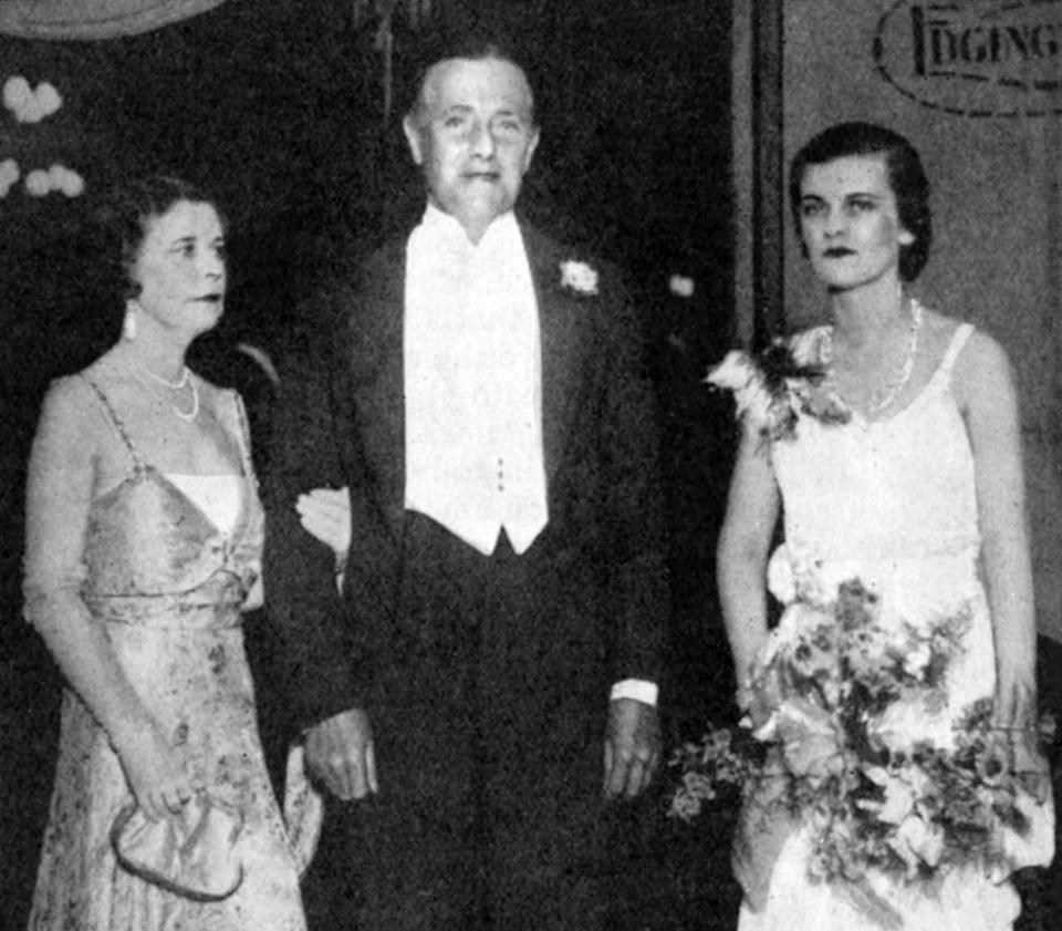 Holding a ball with her parents in 1931