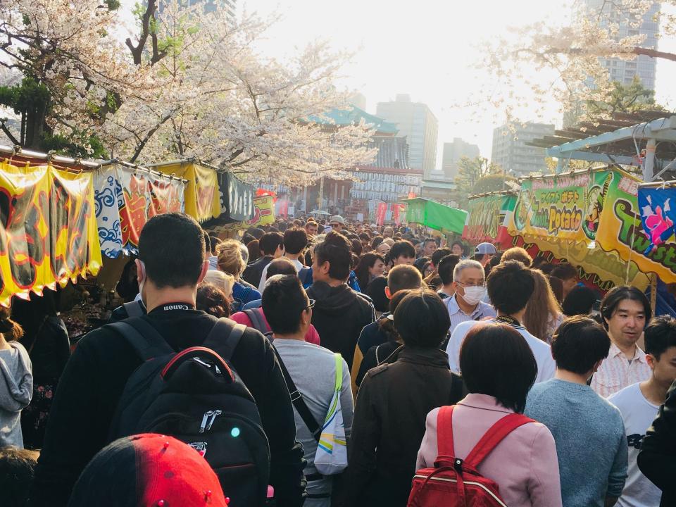 people packed in a street festival in japan during cherry blossom season