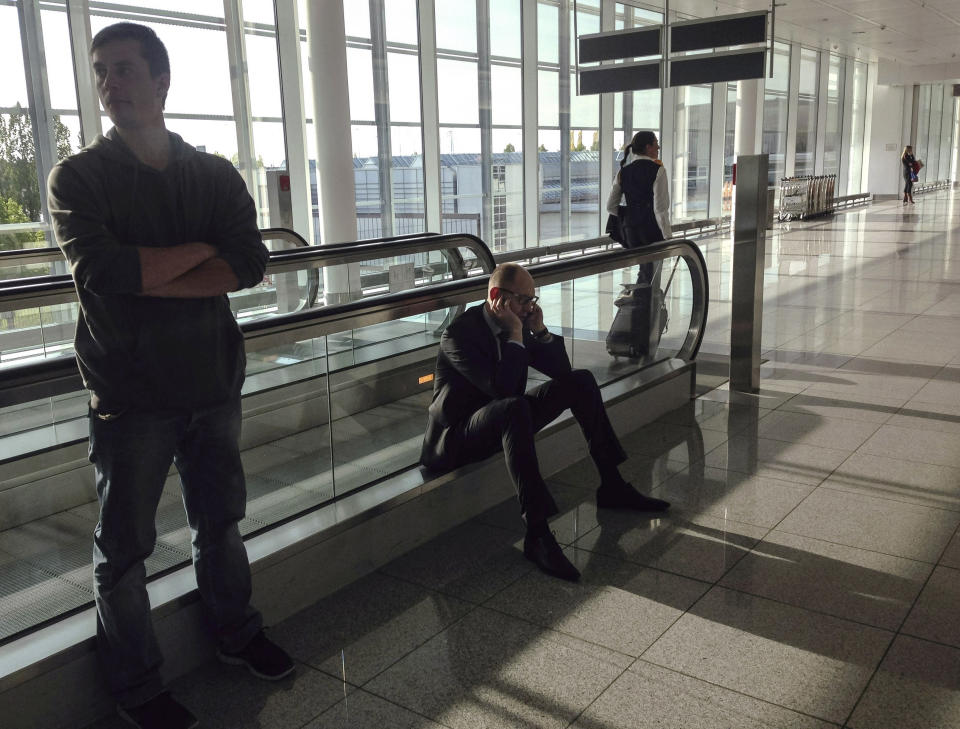 In this April 25, 2014 photo, Ukrainian Prime Minister Arseniy Yatsenyuk talks on his phone at the airport in Munich. Despite being a wealthy man, Yatsenyuk, flies economy when on trips to Western capitals, which is a sharp contrast to his predecessors who preferred government jets or first-class luxury. Yatsenyuk’s interim government is seeking to carry out sweeping reforms to break from a culture of self-interest, cynicism and corruption that left the country on the verge of bankruptcy. (AP Photo/Andrew Kravchenko, Pool)