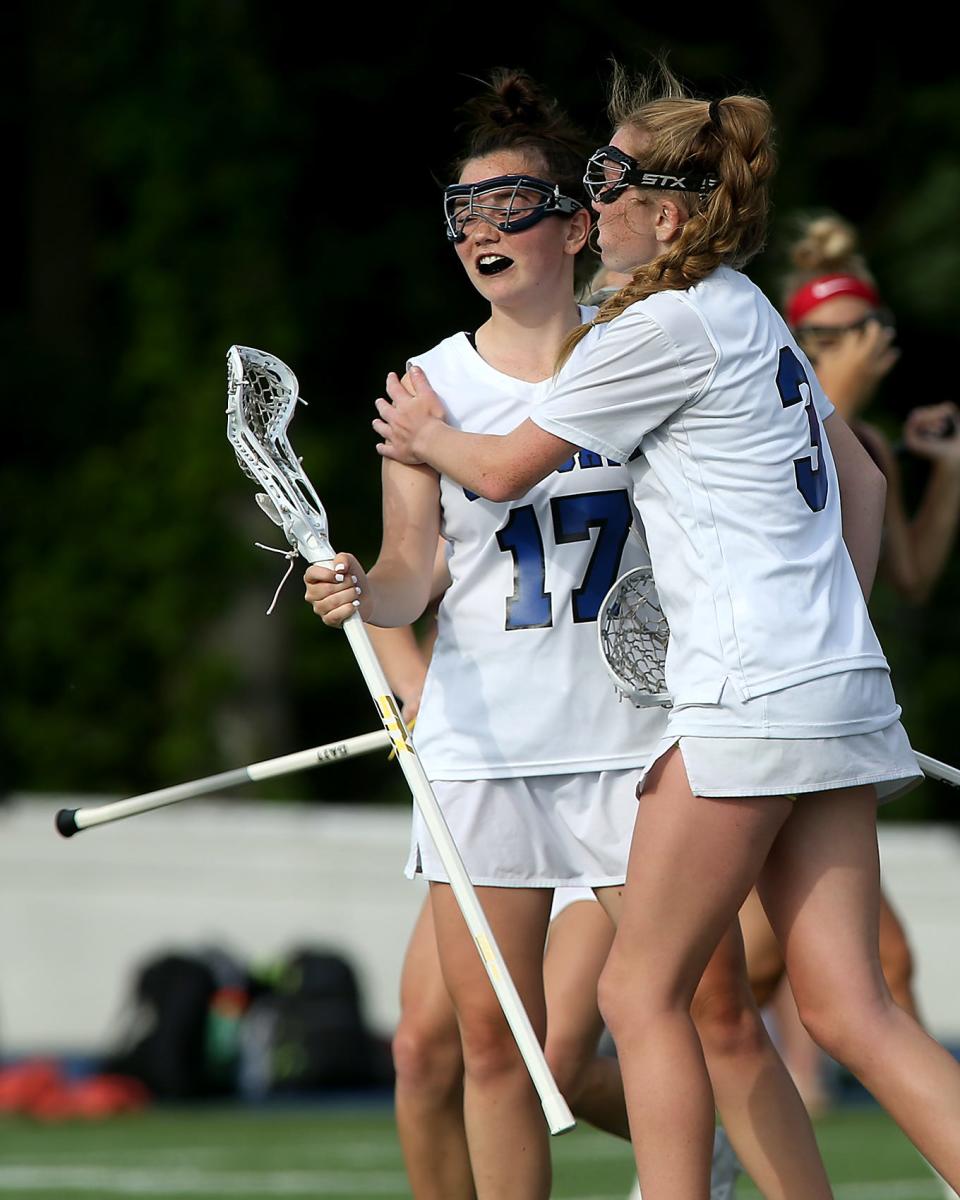 Scituate's Lulu O'Brien gives a hand to Scituate's Katherine Stone after her goal tied the game at 6-6 during first half action of their game against Falmouth in the Round of 32 in the Division 2 state tournament at Scituate High School on Tuesday, June 7, 2022. 